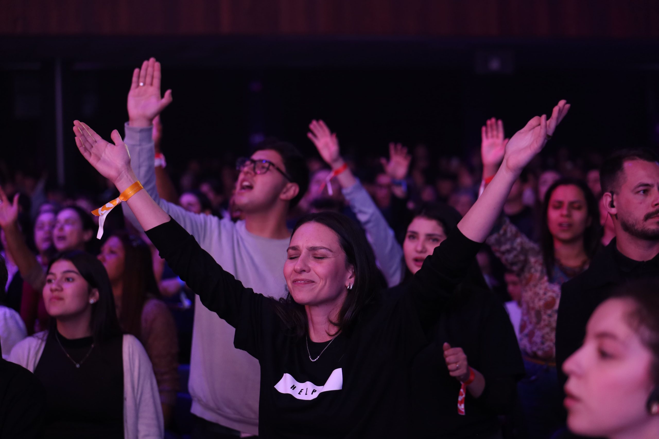 Helper adorando de mãos levantadas no meio do público